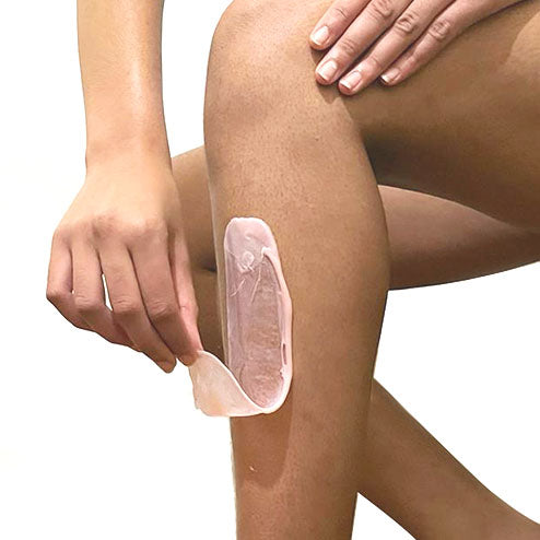 Application d'une bande d'épilation sur une couche de cire sur la jambe